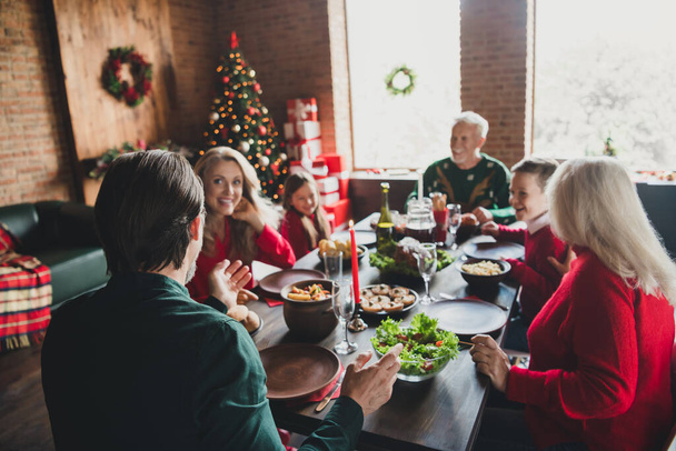 Photo portrait of family sitting at christmas table talking eating spending time together - Foto, immagini