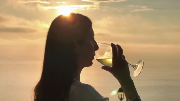 Nainen juo lasillista viiniä auringonlaskun aikaan saaren tausta kesäkaudella - Materiaali, video