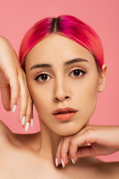 young woman with colorful hair looking at camera isolated on pink  - Foto, Bild