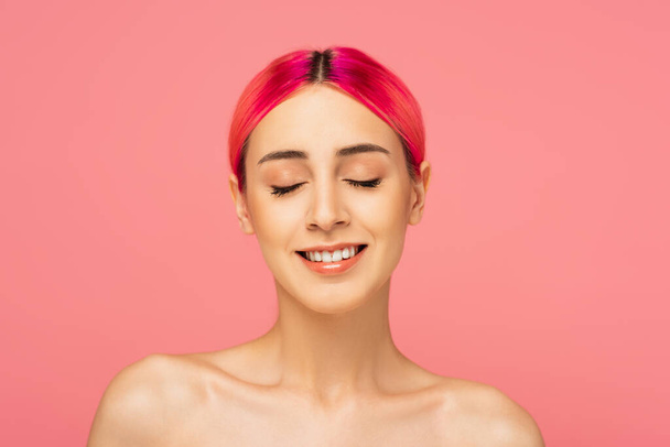 alegre joven con el pelo colorido, hombros desnudos con los ojos cerrados aislados en rosa  - Foto, Imagen