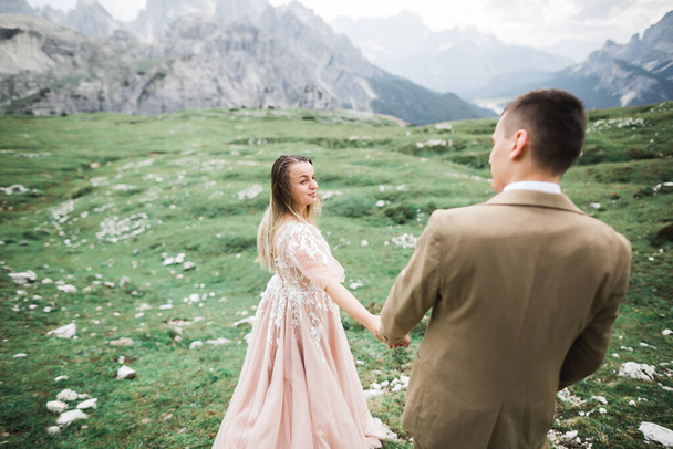 Liefdevolle man en vrouw op de achtergrond van de bergen. Liefdevol koppel brengt emotioneel tijd door - Foto, afbeelding