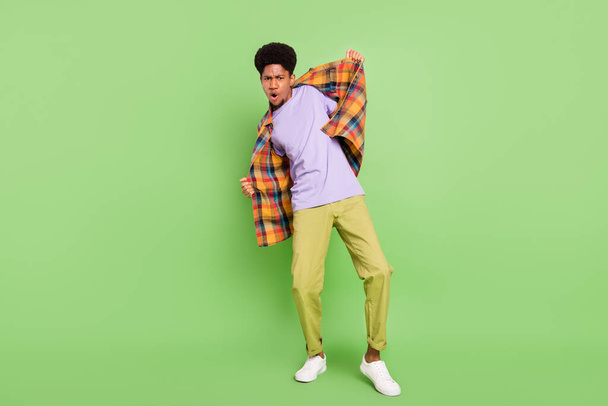 Photo of pretty cool dark skin guy dressed checkered shirt dancing smiling isolated green color background - Foto, imagen