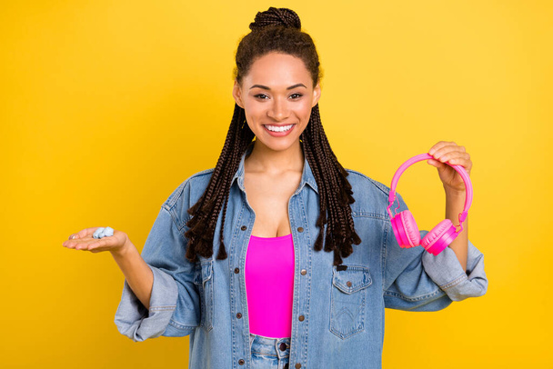 Photo of young black girl happy positive smile hold headphones choice ad isolated over yellow color background - Fotoğraf, Görsel
