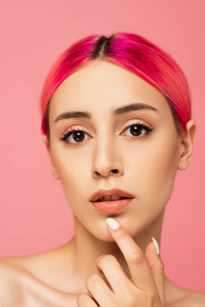 pretty young woman with colorful hair and perfect skin looking at camera isolated on pink  - Fotó, kép