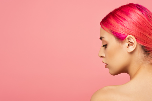 προφίλ της όμορφης νεαρής γυναίκας με πολύχρωμα μαλλιά και γυμνό ώμο απομονωμένο σε ροζ  - Φωτογραφία, εικόνα
