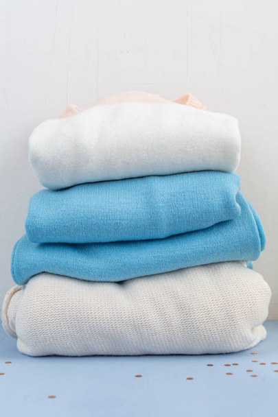 pile de pulls en laine de coton isolés sur fond blanc et bleu clair - Photo, image