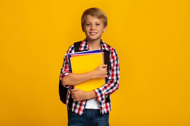 Usmívající se klidný evropský mladý chlapec s knihami a notebooky připraven ke studiu - Fotografie, Obrázek