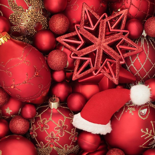 Santa kapelusz i czerwona bombka dekoracje świąteczne tło. Abstrakcyjna kompozycja na świąteczny sezon Bożego Narodzenia. Widok z góry.  - Zdjęcie, obraz