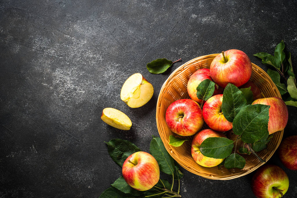Fresh ripe red apples in the basket at white table. - Φωτογραφία, εικόνα