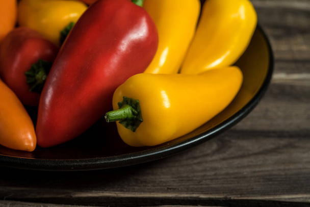 Rural still life with color peppers on wooden background - Photo, Image