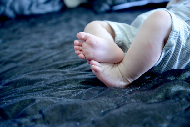 A closeup shot of bare feet of a baby lying on the couch - Foto, immagini