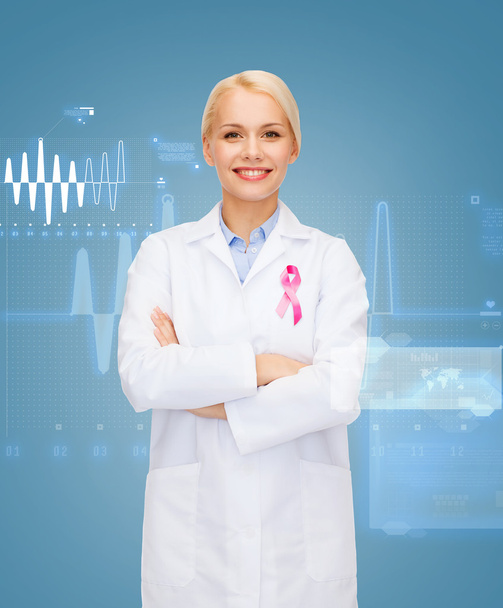 smiling female doctor with cancer awareness ribbon - Zdjęcie, obraz