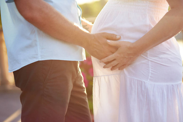 Hamile bir kadının karnına nazikçe dokunmak. Şefkatli hamile çift yakın çekim. Koca göbek. Genç bir aile. Yüksek kalite fotoğraf - Fotoğraf, Görsel