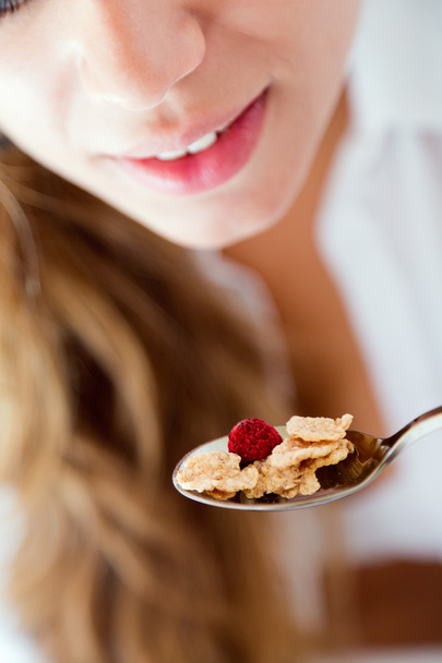 Young woman in underwear eating cereals. Isolated on white. - 写真・画像