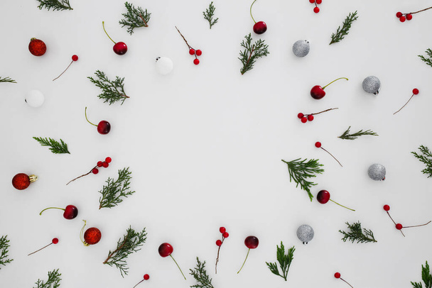 The pine twig pieces, red berries and Christmas toys on the white background - Foto, immagini