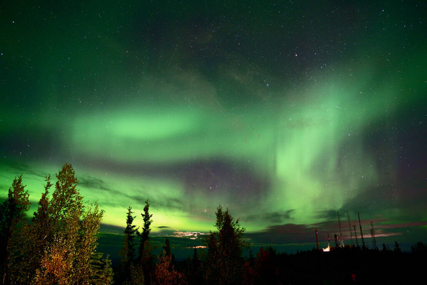 A natural light display of aurora with dynamic patterns of brilliant lights - Foto, afbeelding