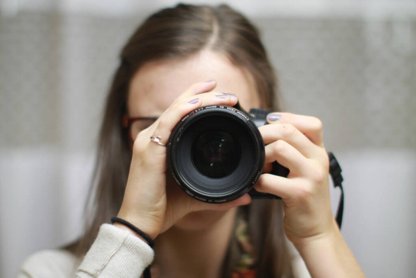 A closeup shot of a female using a professional camera - Zdjęcie, obraz