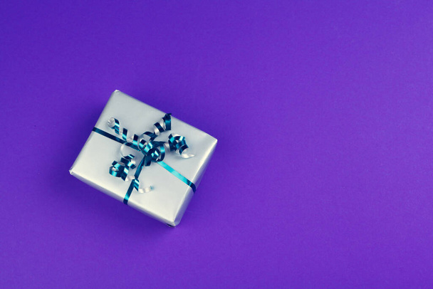 Gift box on purple background top view - 写真・画像