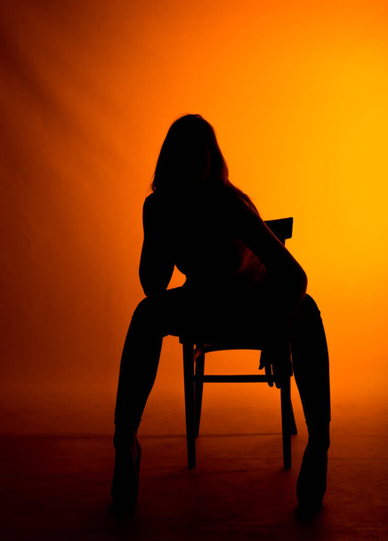 Körperbild einer stilvollen Frau, die in schwarzen High Heels und Langarmshirt posiert - Foto, Bild
