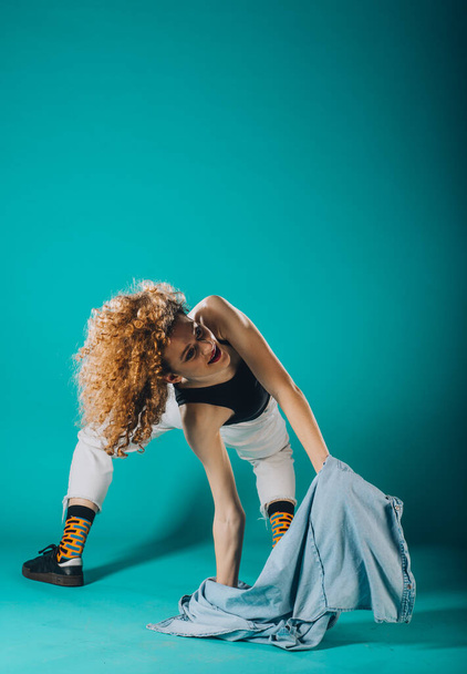 Flexible young dancer performing a stylish dance movement - Foto, afbeelding