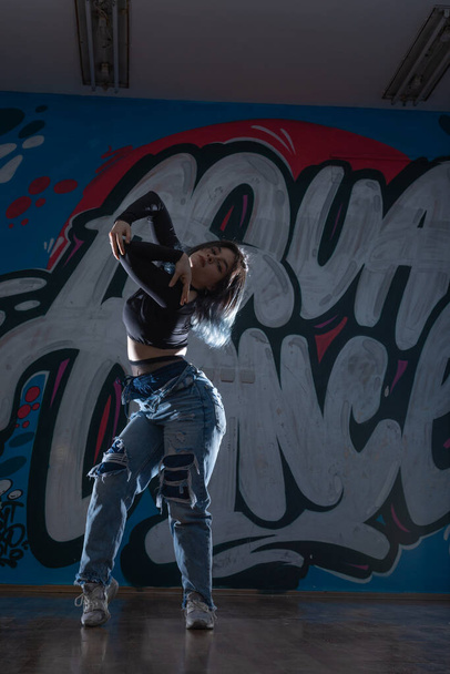 Ženský tanečník na podlaze moderního tanečního ateliéru a dívá se na tebe - Fotografie, Obrázek
