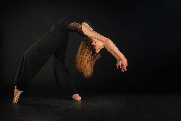 Bailarina está dobrando tanto enquanto posando e equilibrando em sapatos pontiagudos - Foto, Imagem