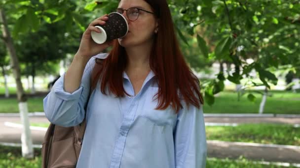 4k Primer plano de la joven empresaria sosteniendo una taza de café y bebida al aire libre en el parque de verano - Metraje, vídeo