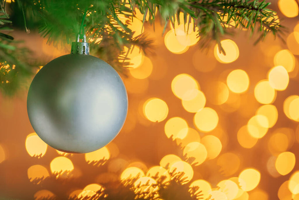 Christmas tree background with grey bauble on golden bokeh sparkling - Фото, изображение