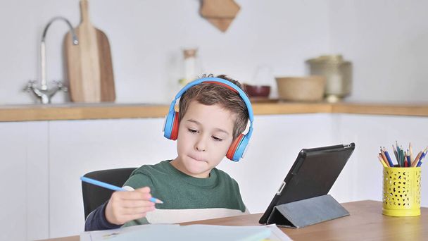 Smart boy student listen to online lesson on tablet wear headphones Spbas. Homeschooled child watch. - Photo, Image