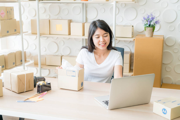 Asian Women business owner working at home with packing box on workplace - online shopping or sell online concept - 写真・画像