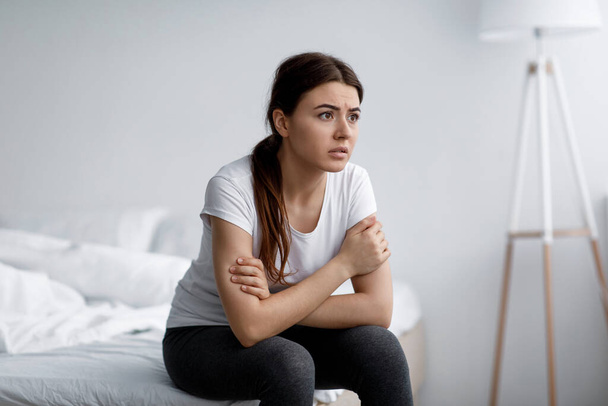 Сумна тривога молода приваблива біла жінка страждає від психічних проблем, стресу і безсоння сидить на ліжку
 - Фото, зображення