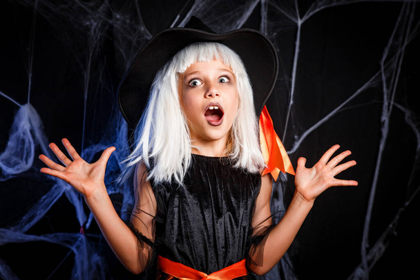 Little girl in witch costume having fun on Halloween trick or treat - Foto, afbeelding