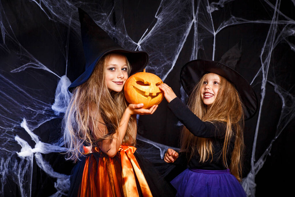 Two little kids in witch costumes having fun on Halloween - Foto, imagen