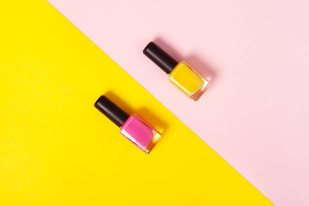 top view pink and yellow nail polish  with background of the same color with copy space. Minimal concept. - Photo, Image