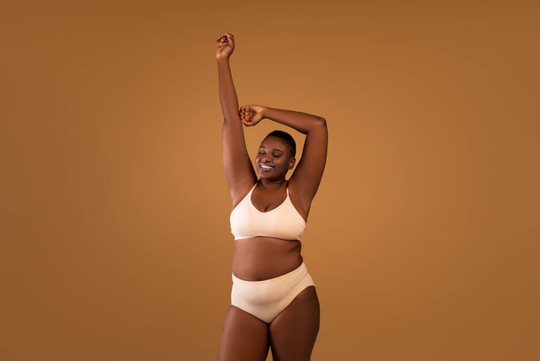 Beautiful plus size African american woman raising hands - Фото, изображение