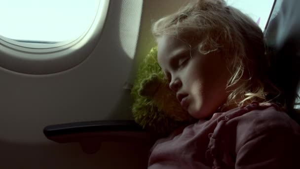 Malá holčička spí na sedadle letadla. - Záběry, video