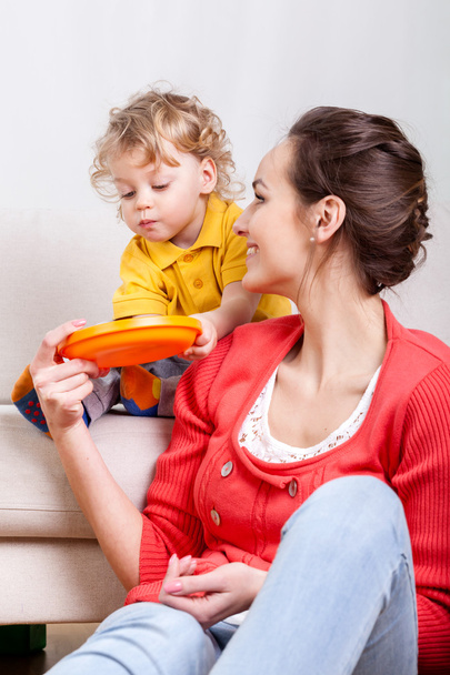 Child eating while mom helps - Photo, image