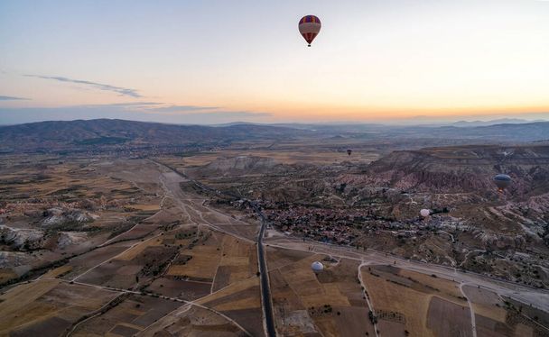 Wide panorama of Cappadocia landscape - colored balloons flying over mountain peaks and fantastic valley. Air balloons above Turkish National Park in Goreme. Cappadocia, Goreme, Anatolia, Turkey - Fotoğraf, Görsel