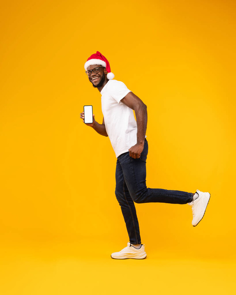 Santa Şapkalı Siyah Adam Telefon Ekranı, Sarı Arkaplan - Fotoğraf, Görsel