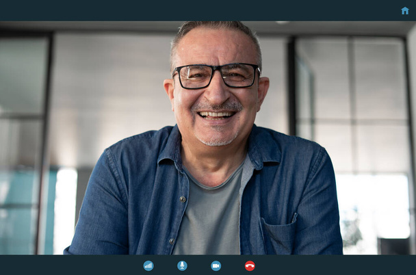 Senior man talking to webcam - Fotografie, Obrázek