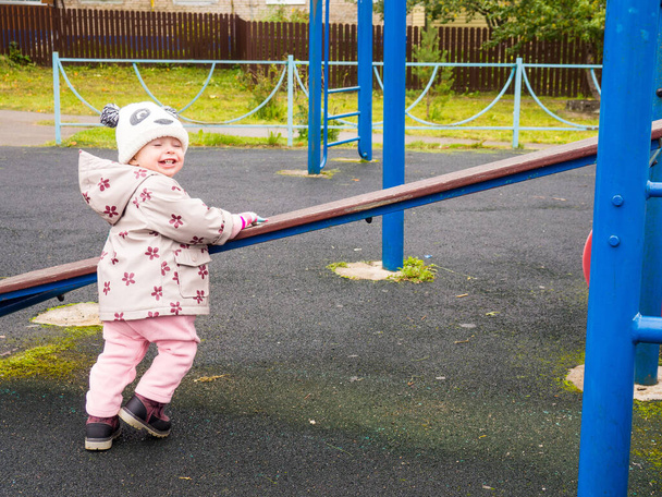 bambino carino e divertente che gioca nel parco giochi in una giornata autunnale - Foto, immagini
