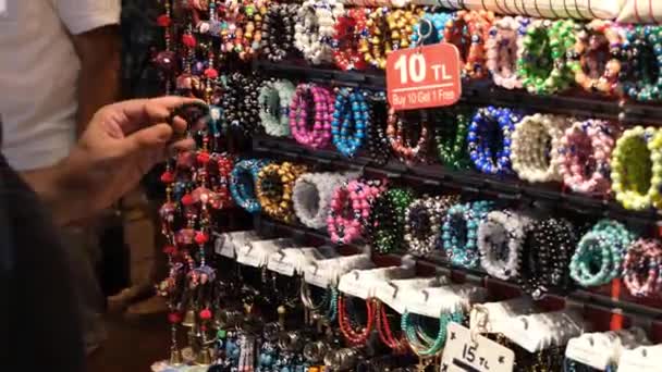 купуючи браслет, чоловік купує браслет на великому базарі
 - Кадри, відео