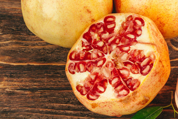 Cut pomegranate fruit on a wooden board - Photo, Image