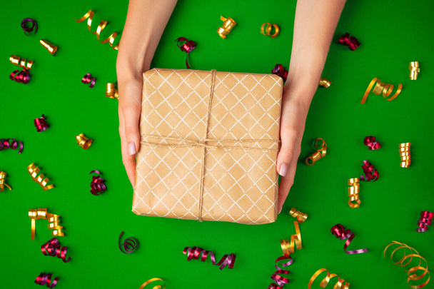 Woman hands holding gift box top view - 写真・画像