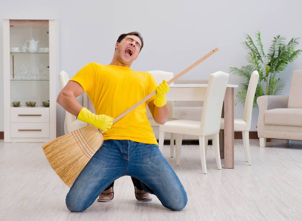 Funny man playing virtual guitar with broom - Foto, immagini