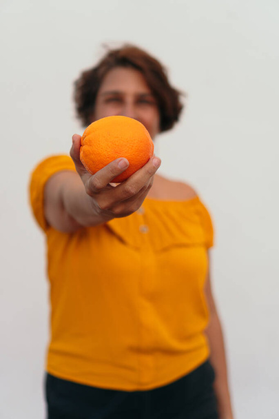 жінка насолоджується сонячним днем з апельсином
 - Фото, зображення