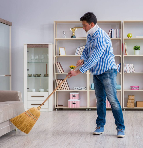 Man with neck unjury cleaning house in housekeeping concept - Photo, Image