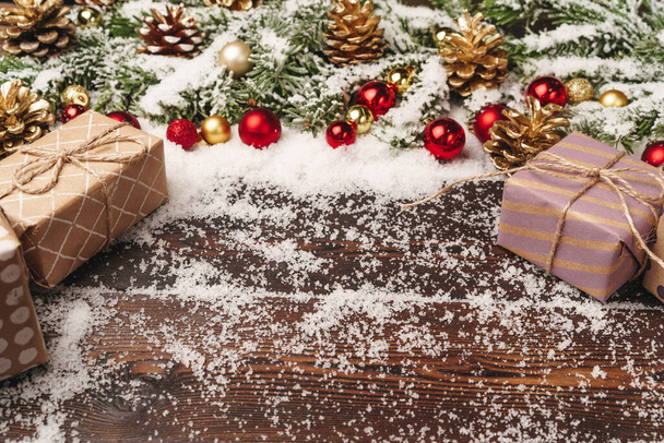 Festive gift with bow close up on wooden background with snow - Foto, Imagem