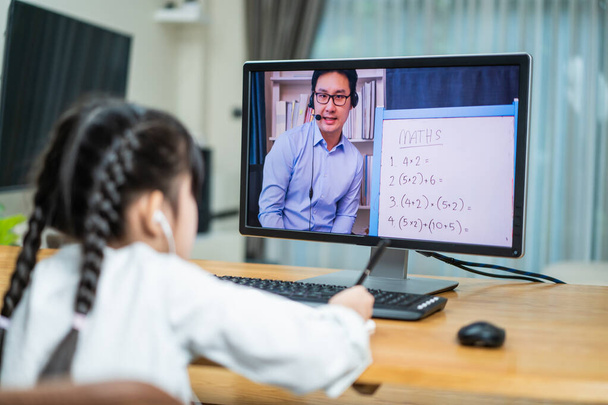 Азійська дівчина дивиться віртуальне відео онлайн, вчиться на ноутбуці вдома. Домашня дитина користується комп "ютерним вивченням і слухає шкільного вчителя за допомогою цифрової зустрічі на віддалених конференціях.. - Фото, зображення