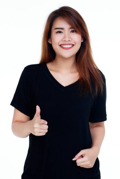 attractive cutout portrait of beautiful young healthy woman on black shirt standing with smile on her pretty face and thumbs up as something looks perfectly good for her life style - Photo, Image